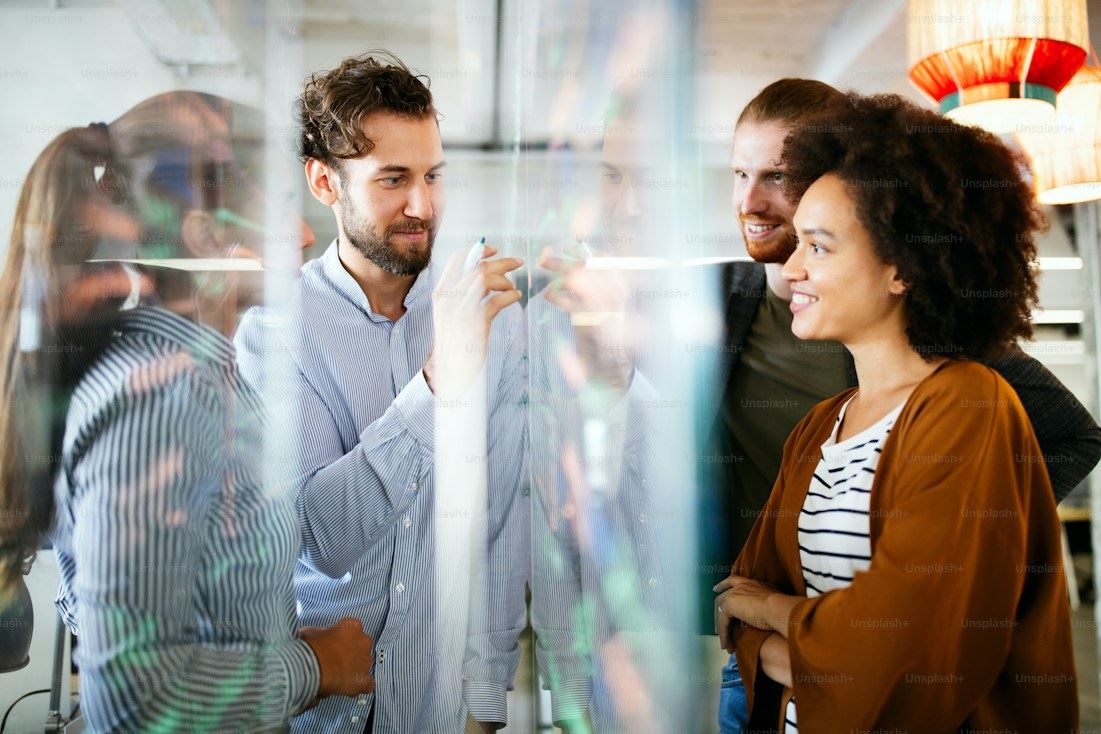 A team collaborating around a glass board in a bright office